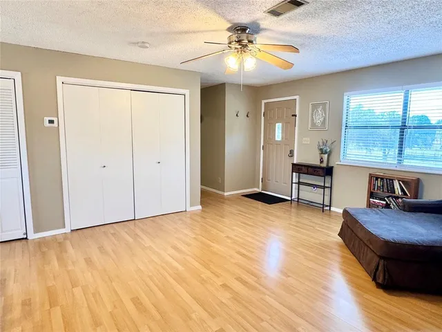 an empty room with wooden floor and windows