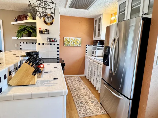 a kitchen with stainless steel appliances granite countertop a refrigerator and a stove