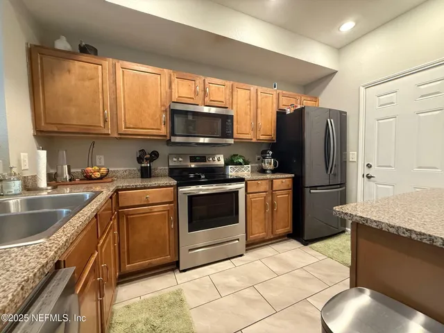 a kitchen with a sink a stove top oven and cabinetry