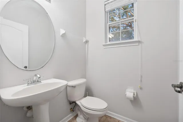 a bathroom with a sink mirror and toilet