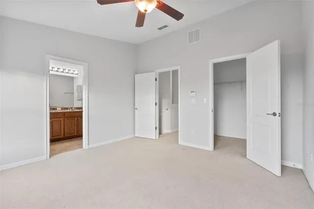 an empty room with closet and a chandelier fan