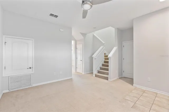 a view of an empty room with stairs and ventilation