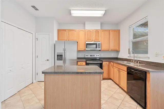 a kitchen with stainless steel appliances granite countertop a stove a sink and a refrigerator