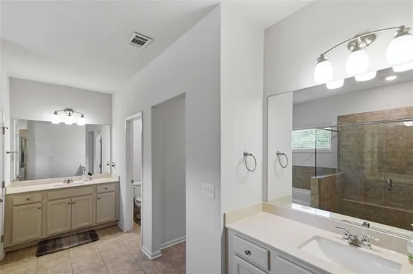 a bathroom with a double vanity sink mirror and shower