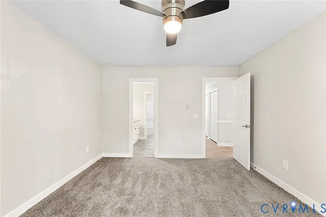 an empty room with ceiling fan and window