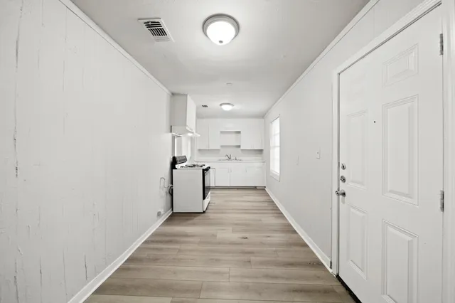 a view of a hallway with wooden floor