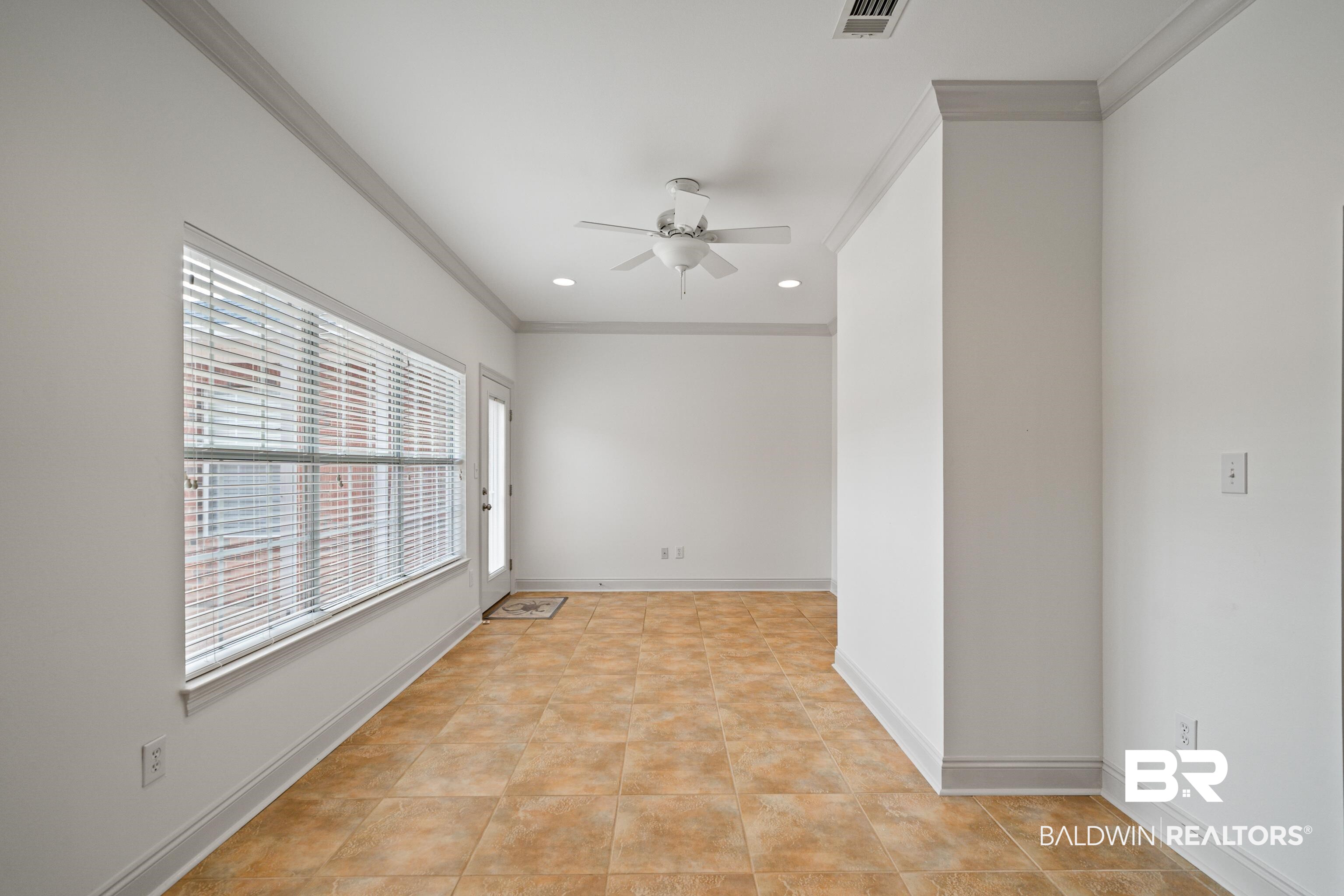 404 Savannah Lane Foley, AL 36535 - Photo 10 of 29 Spare room featuring baseboards, ceiling fan, visible vents, and crown molding