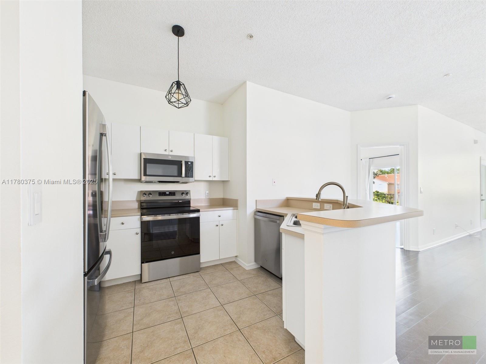 112 Lighthouse Circle, Unit H Tequesta, FL 33469 - Photo 14 of 20 a kitchen with a sink a stove top oven and refrigerator