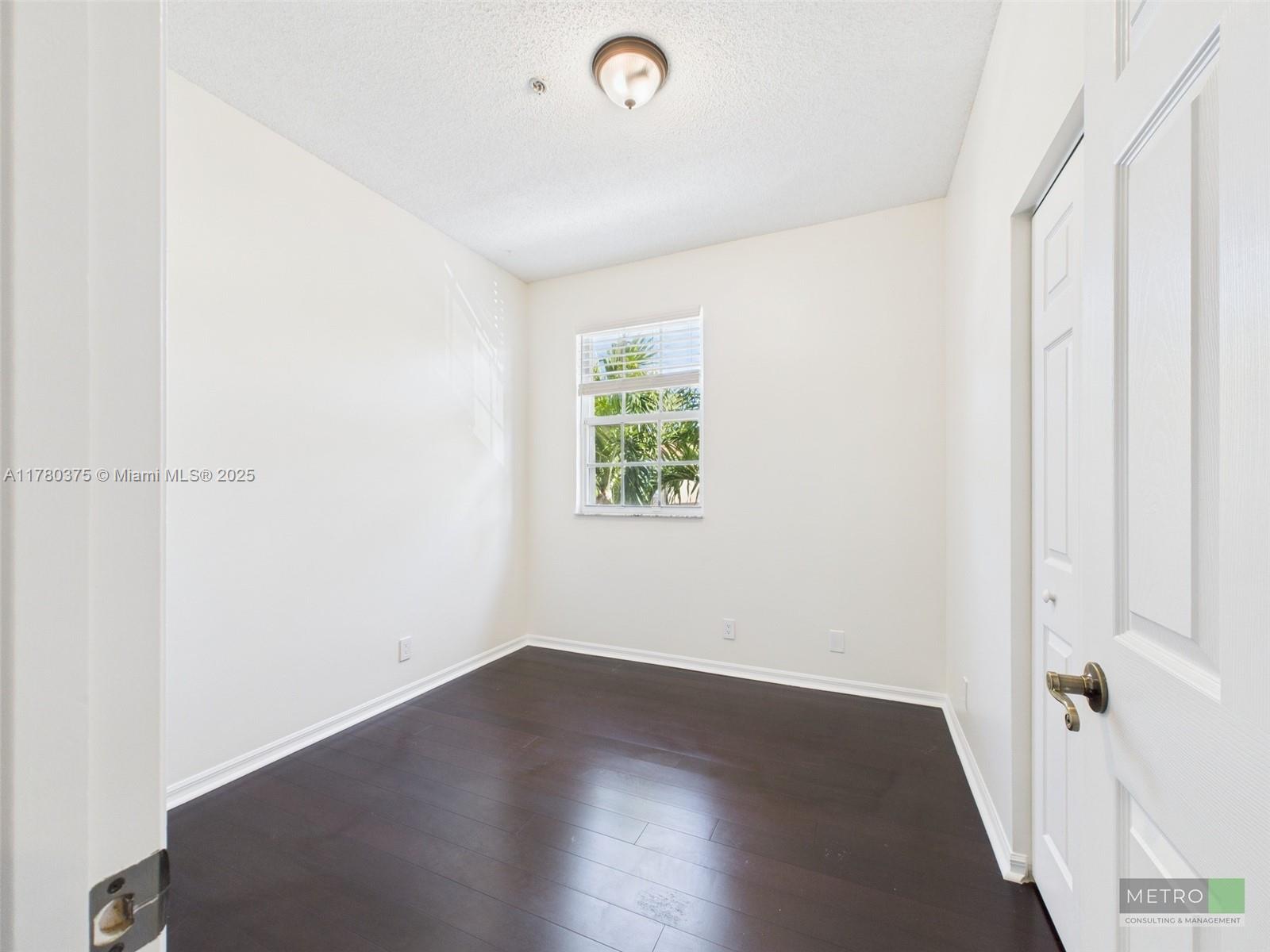 112 Lighthouse Circle, Unit H Tequesta, FL 33469 - Photo 15 of 20 an empty room with wooden floor and windows