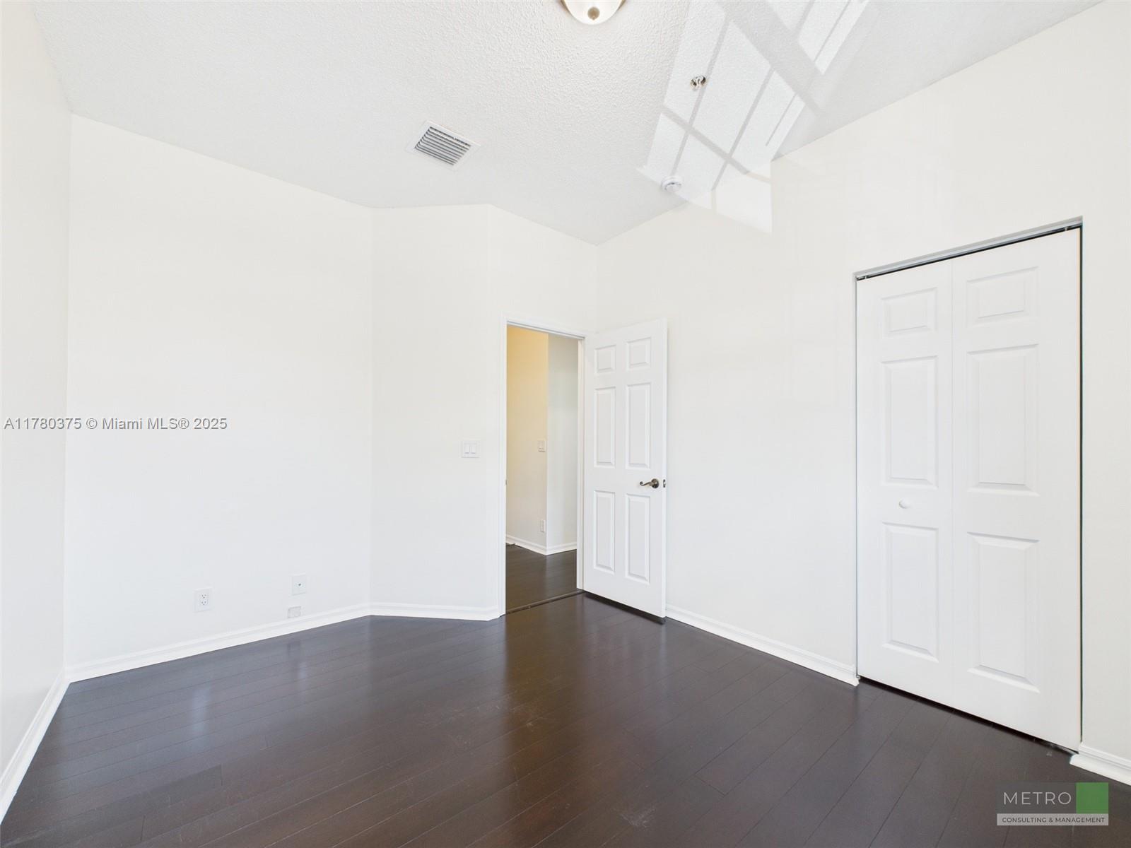 112 Lighthouse Circle, Unit H Tequesta, FL 33469 - Photo 17 of 20 an empty room with wooden floor and white walls