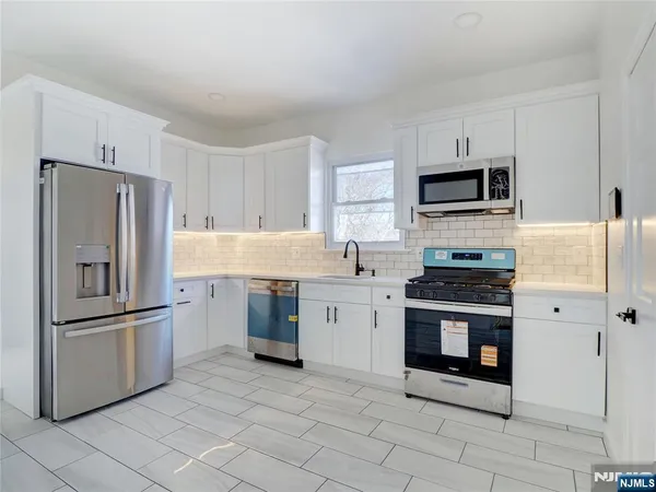 a kitchen with cabinets stainless steel appliances and a counter space