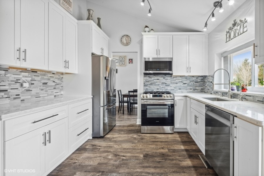 844 Burning Trail Carol Stream, IL 60188 - Photo 3 of 21 a kitchen with granite countertop a stove top oven microwave and refrigerator
