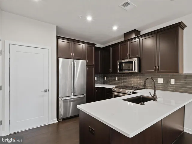 a kitchen with a refrigerator a sink and cabinets