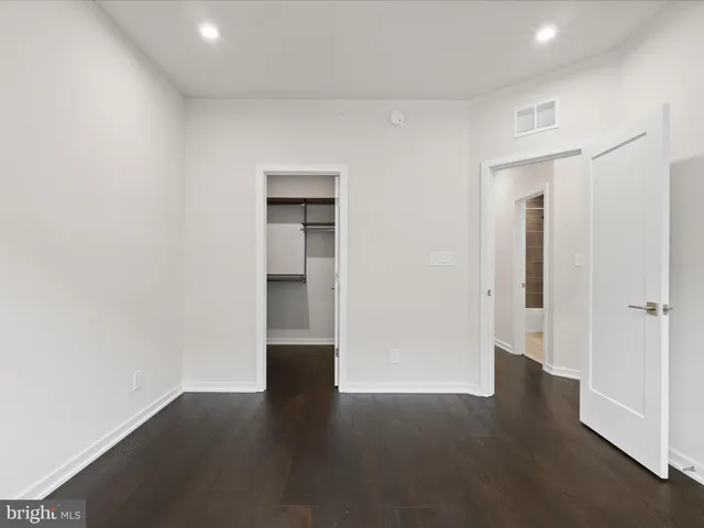 an empty room with wooden floor and closet