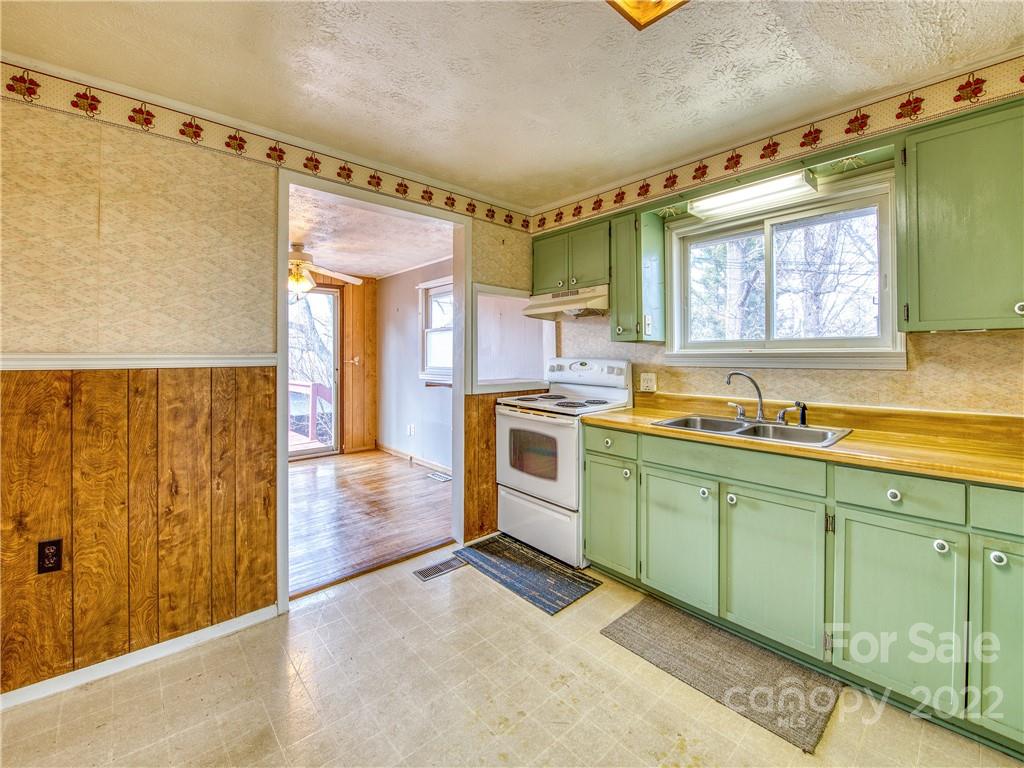 220 Center Pigeon Road Canton, NC 28716 - Photo 13 of 24 a kitchen with a sink window and cabinets