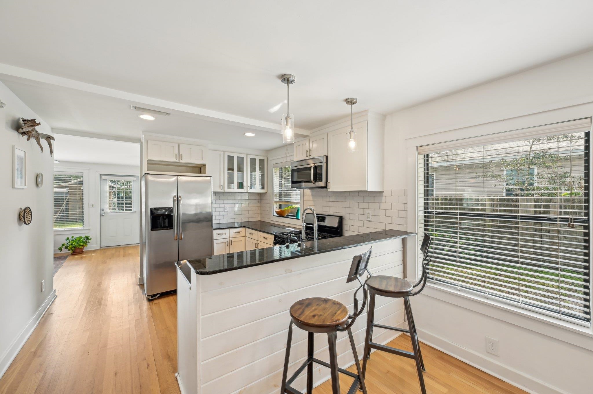 7 Atlantic Avenue St. Augustine, FL 32084 - Photo 16 of 38 a kitchen with stainless steel appliances granite countertop a refrigerator a sink dishwasher a stove and white cabinets with wooden floor
