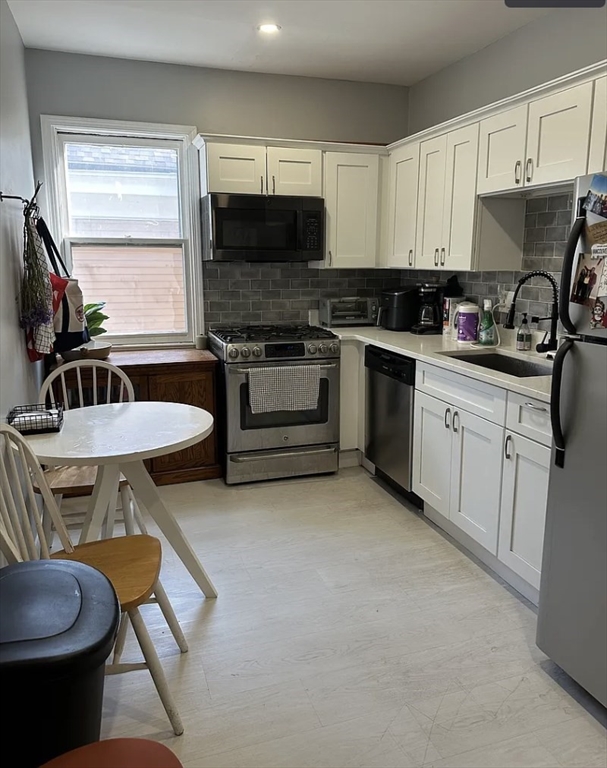 183 Prospect Street, Unit 2 Cambridge, MA 02139 - Photo 3 of 11 a kitchen with a stove a sink and a microwave