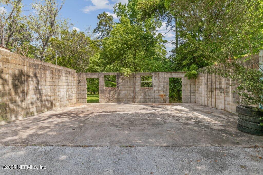 45121 Stratton Road Callahan, FL 32011 - Photo 16 of 24 a backyard of a house with large trees and brick walls