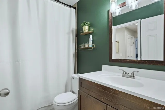 a bathroom with a sink vanity mirror and toilet