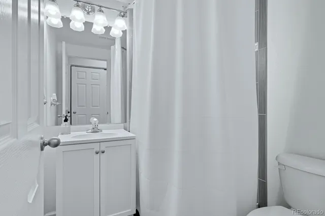 a bathroom with a sink a toilet and mirror