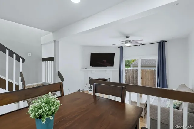 a view of a livingroom with furniture a flat screen tv wooden floor and front door