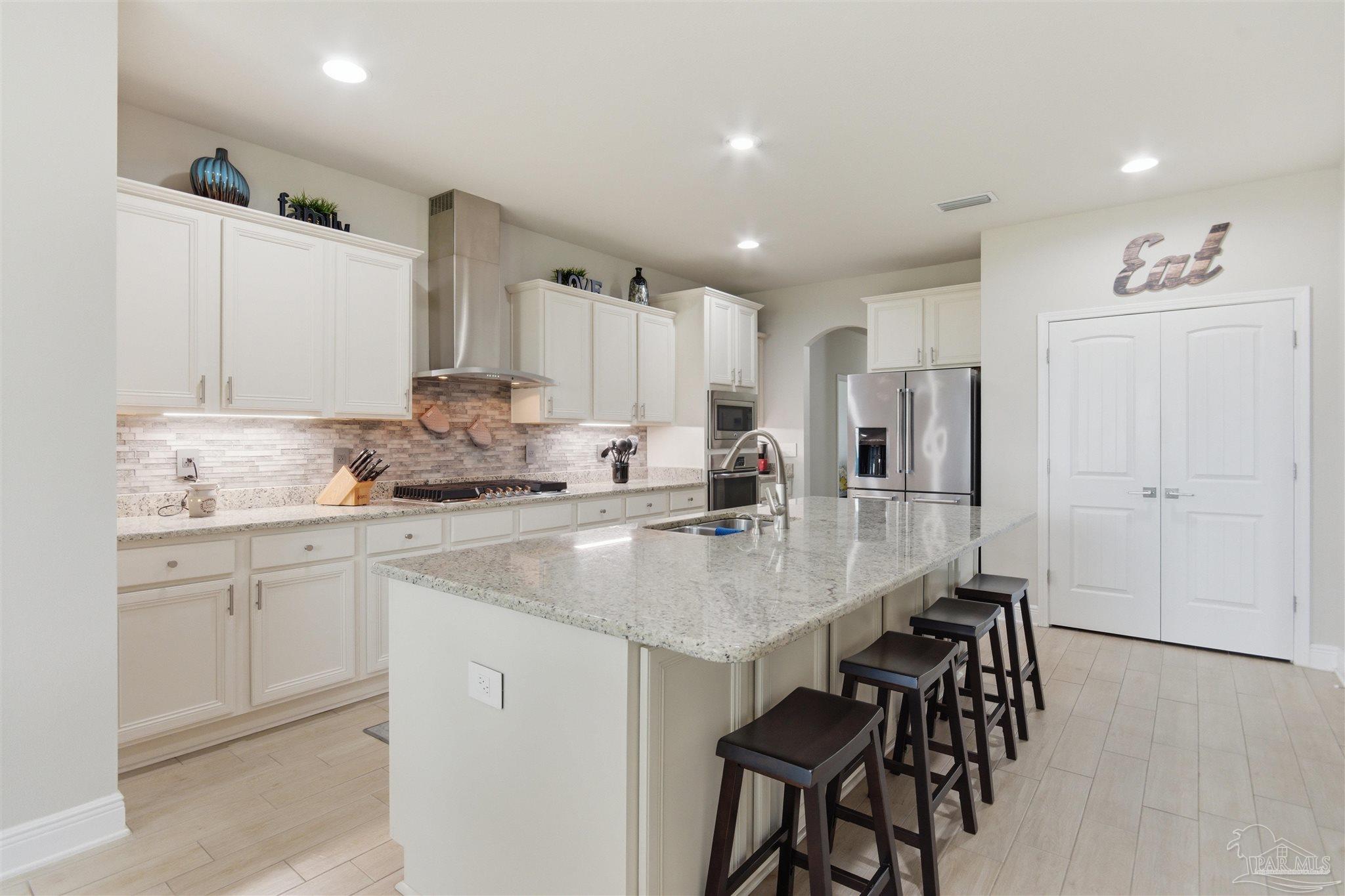 2677 Tulip Hill Road Pace, FL 32571 - Photo 13 of 35 a kitchen with stainless steel appliances granite countertop a table chairs sink refrigerator and cabinets