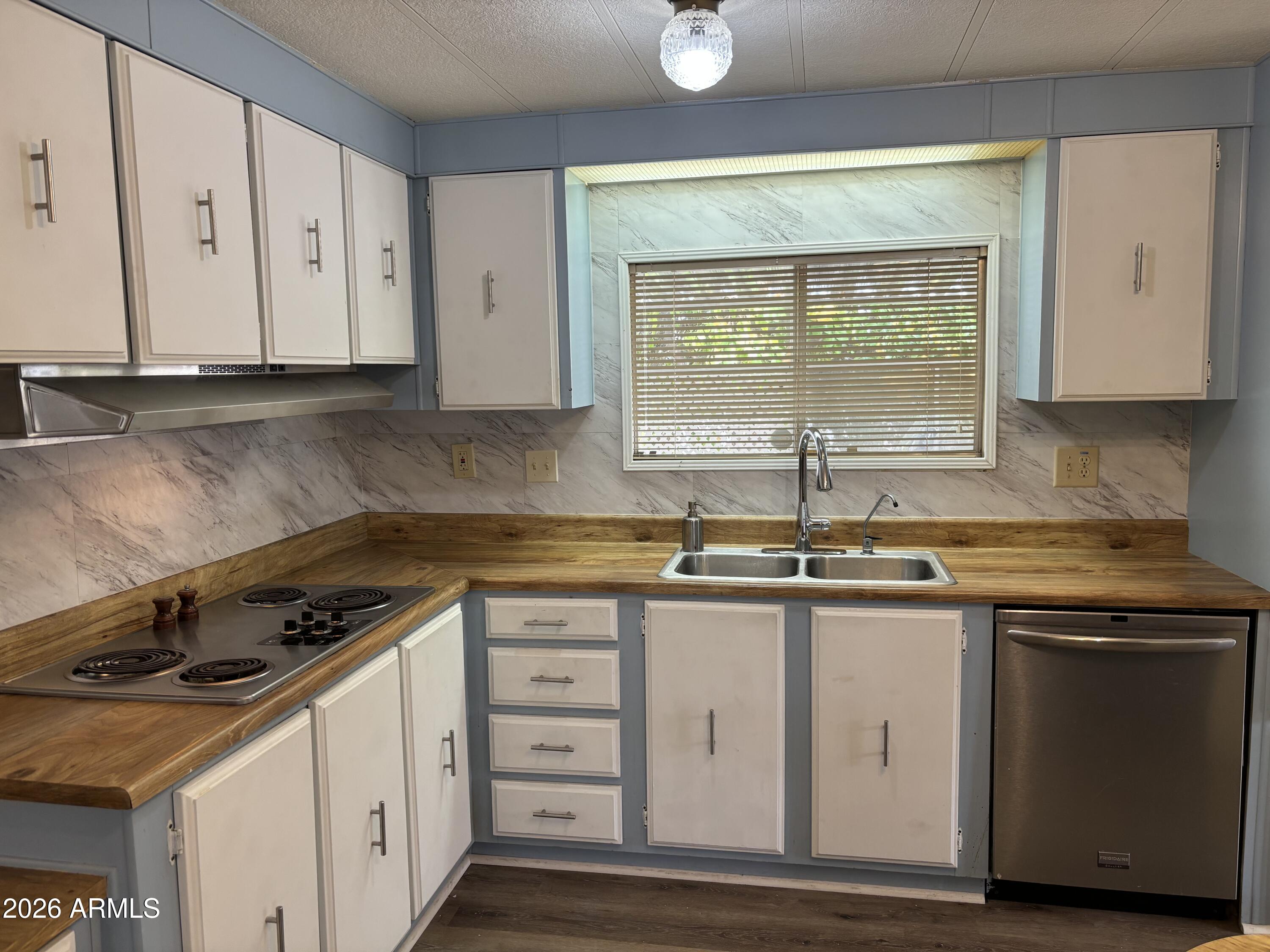 5546 East Player Place Mesa, AZ 85215 - Photo 7 of 8 a kitchen with granite countertop a sink stove and cabinets