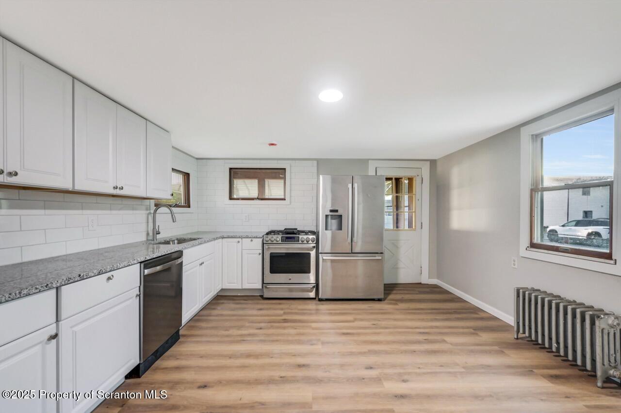 201 Jackson Street Olyphant, PA 18447 - Photo 23 of 70 a kitchen with granite countertop a stove top oven sink and cabinets