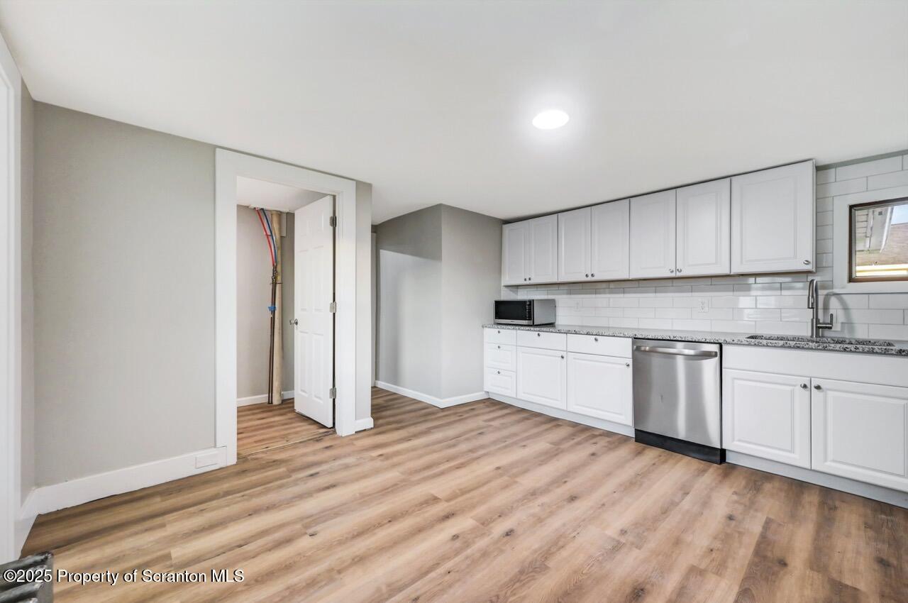 201 Jackson Street Olyphant, PA 18447 - Photo 26 of 70 a kitchen with granite countertop white cabinets and white appliances