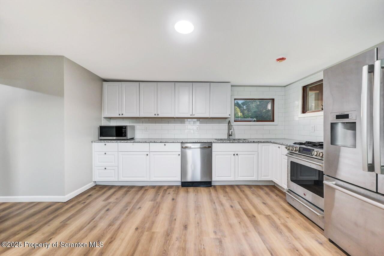 201 Jackson Street Olyphant, PA 18447 - Photo 27 of 70 a kitchen with granite countertop white cabinets and stainless steel appliances