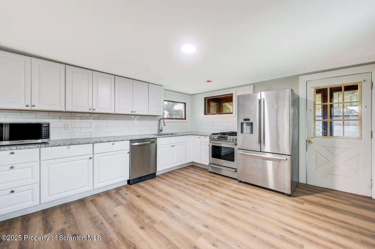 201 Jackson Street Olyphant, PA 18447 - Photo 28 of 70 a kitchen with granite countertop white cabinets and stainless steel appliances