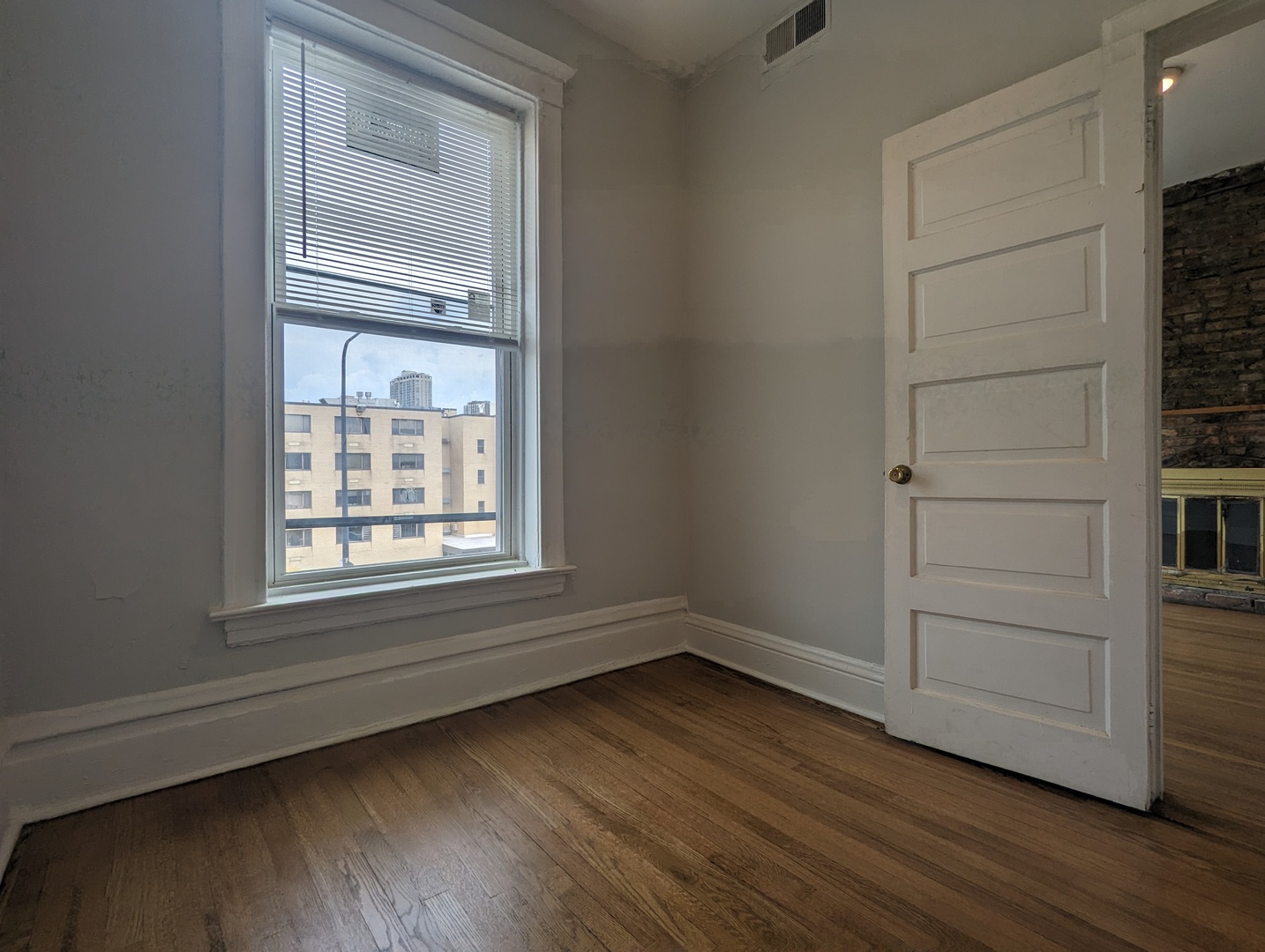 3544 North Halsted Street, Unit 3F Chicago, IL 60657 - Photo 11 of 28 a view of an empty room with wooden floor and a window