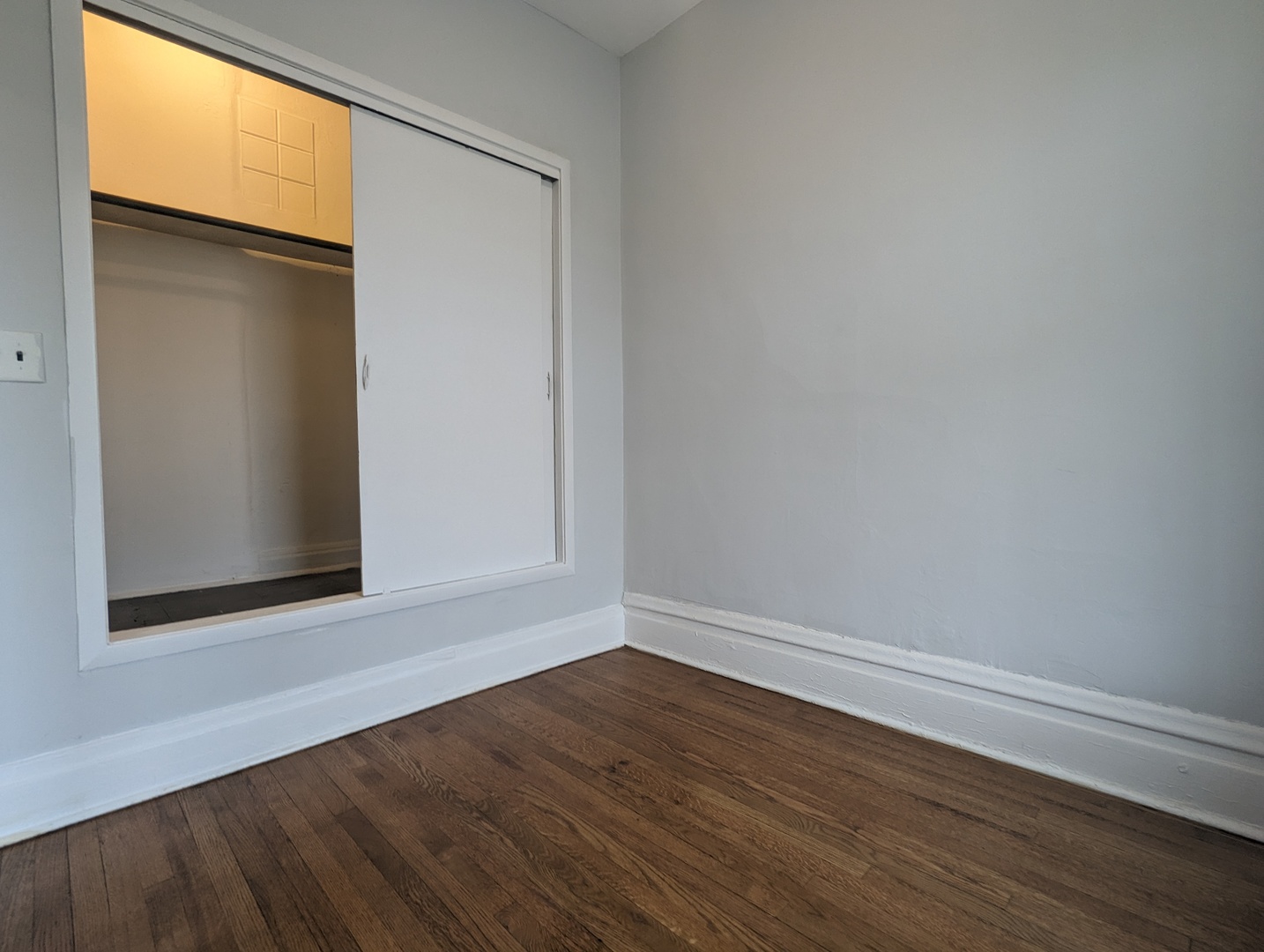 3544 North Halsted Street, Unit 3F Chicago, IL 60657 - Photo 12 of 28 a view of an empty room with wooden floor and a window