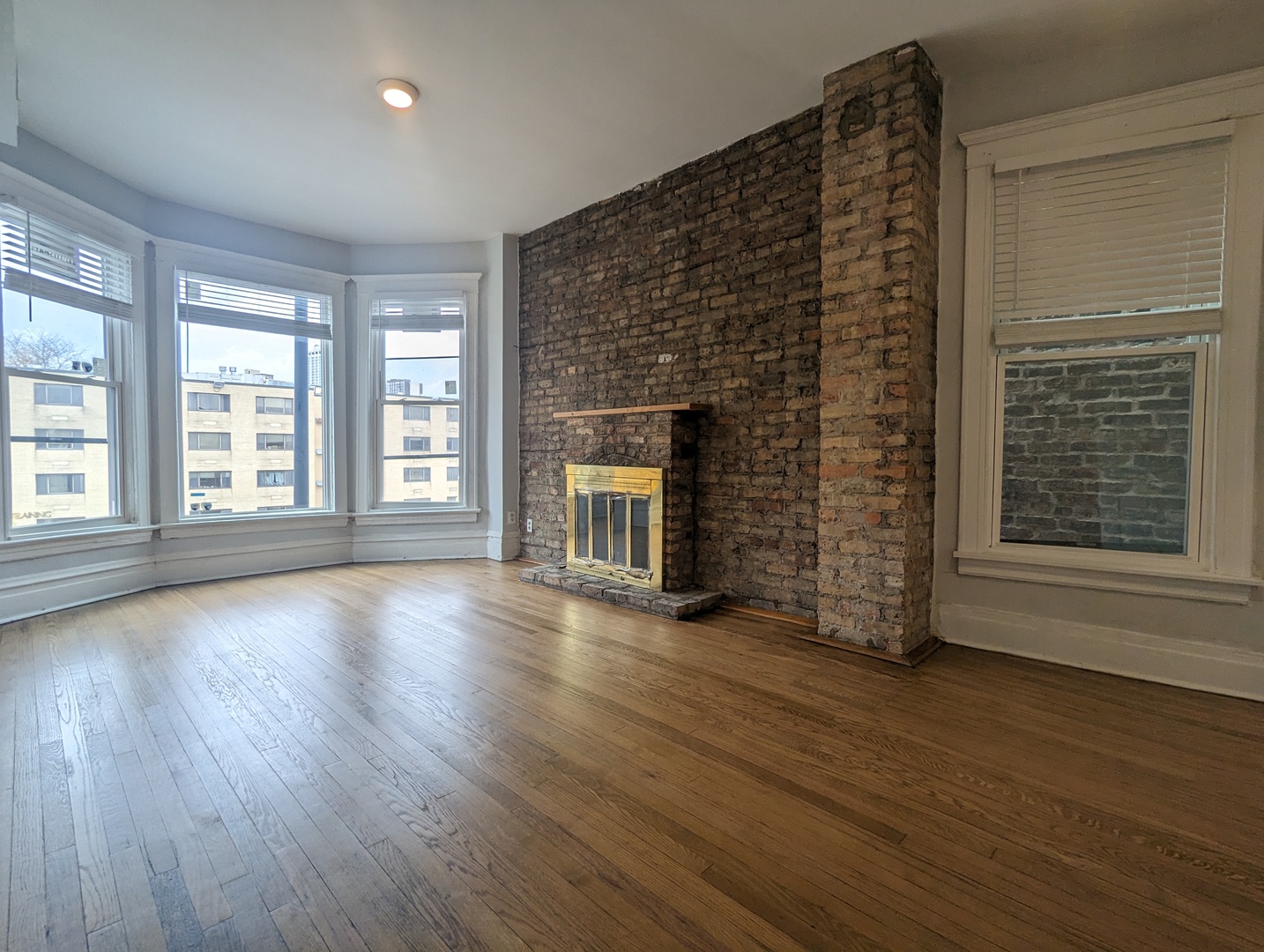 3544 North Halsted Street, Unit 3F Chicago, IL 60657 - Photo 2 of 28 a view of an empty room with wooden floor and a window