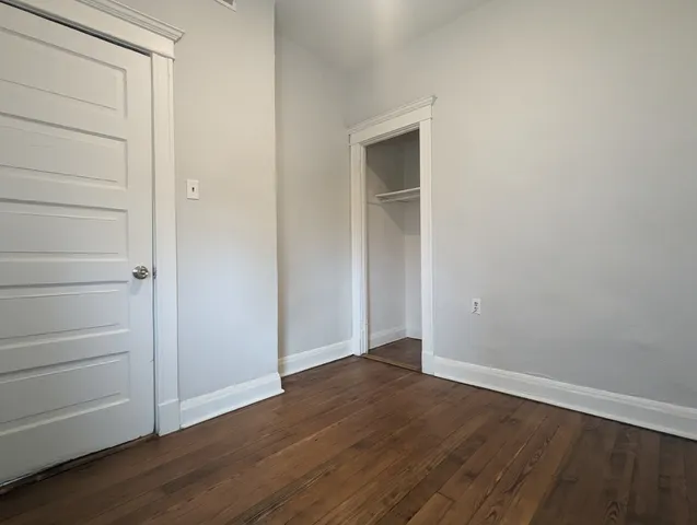 a view of an empty room with closet and a window