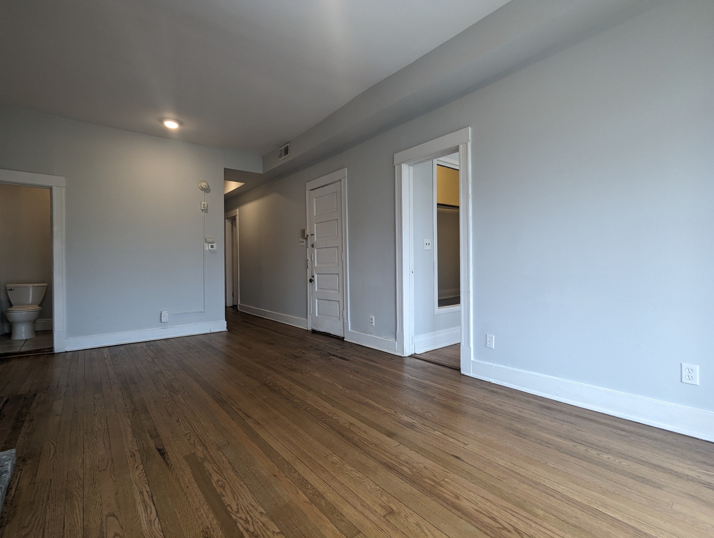 3544 North Halsted Street, Unit 3F Chicago, IL 60657 - Photo 7 of 28 a view of an empty room with wooden floor and closet