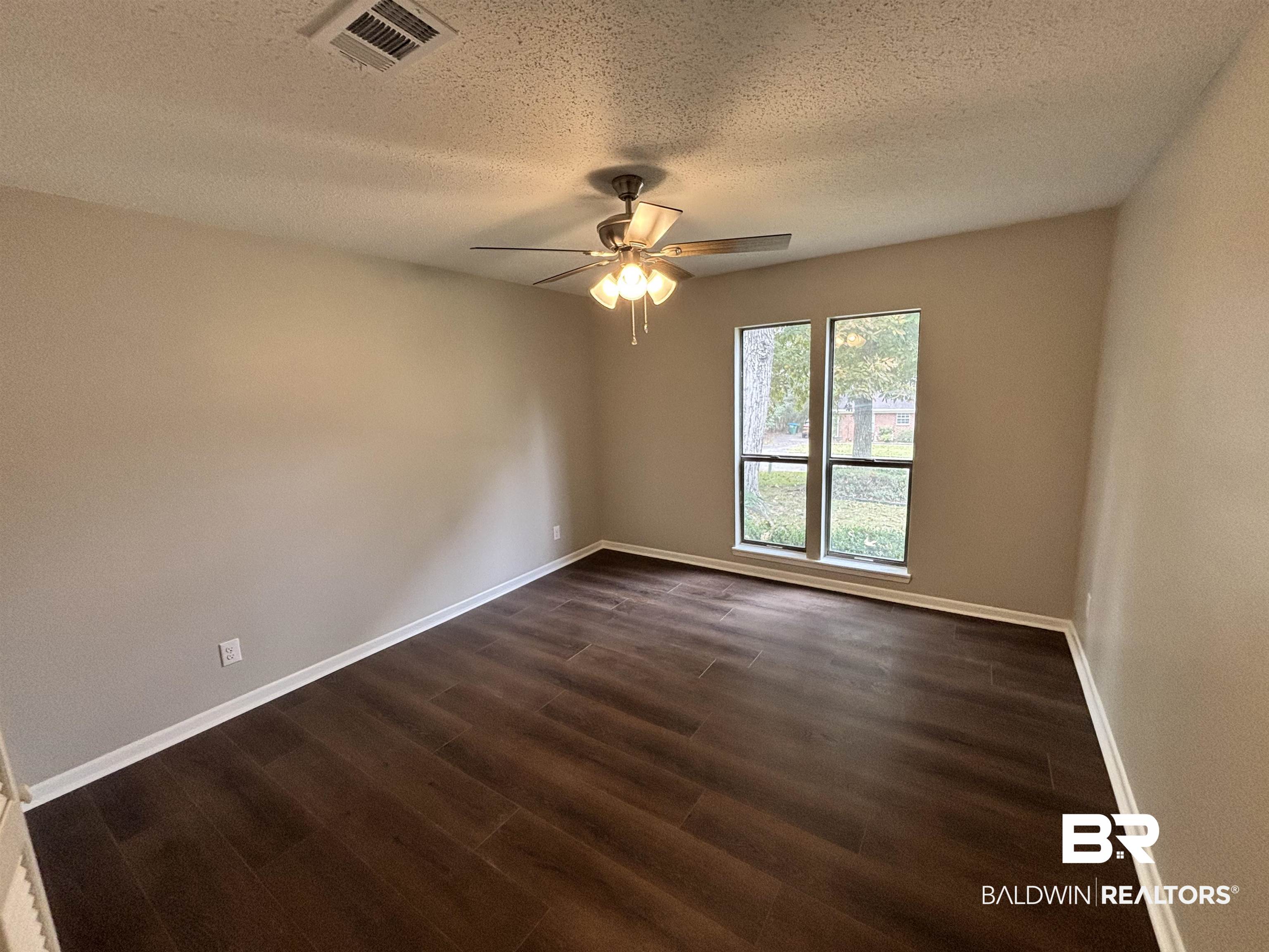10 Soldiers Route Daphne, AL 36527 - Photo 20 of 26 Spare room with dark wood-type flooring, a textured ceiling, and a ceiling fan