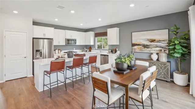 a dining room with furniture potted plants and wooden floor