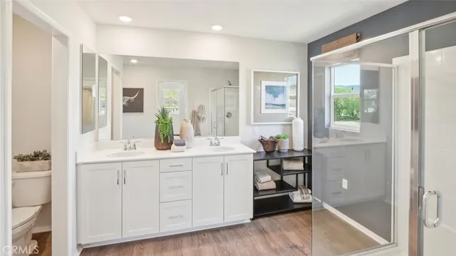 a spacious bathroom with a double vanity sink a mirror and a shower