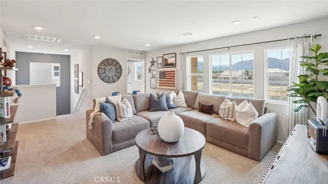 a living room with furniture a large window and a clock