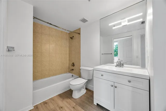 a bathroom with a sink a toilet a large mirror and shower