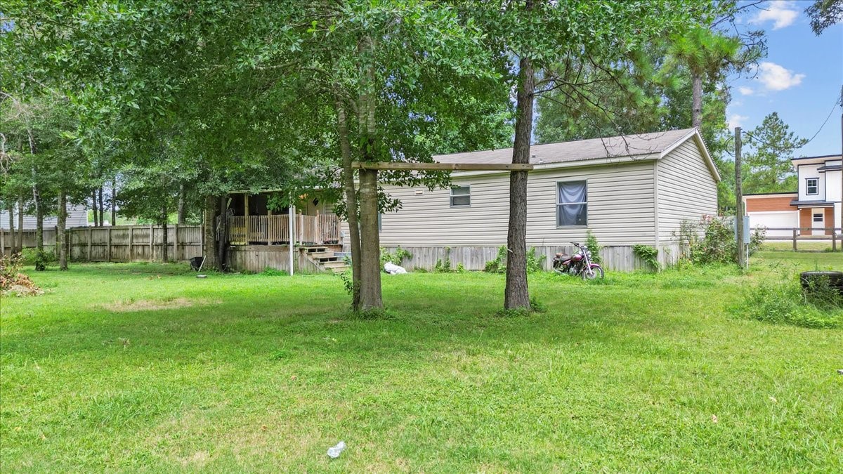 21658 County Road 3749D Cleveland, TX 77327 - Photo 12 of 26 a backyard of a house with plants and large tree