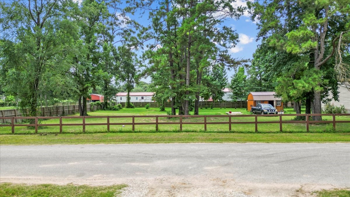 21658 County Road 3749D Cleveland, TX 77327 - Photo 18 of 26 a front view of a house with a garden and trees