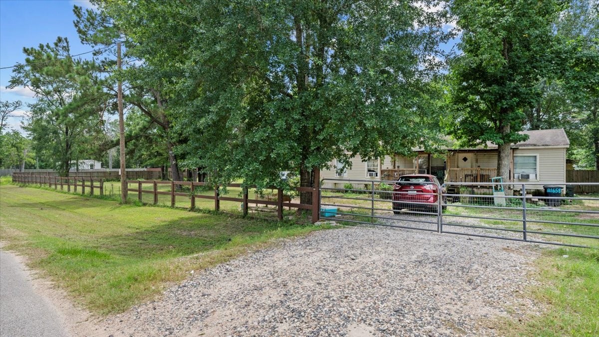 21658 County Road 3749D Cleveland, TX 77327 - Photo 6 of 26 a view of a park with wooden fence and a bench