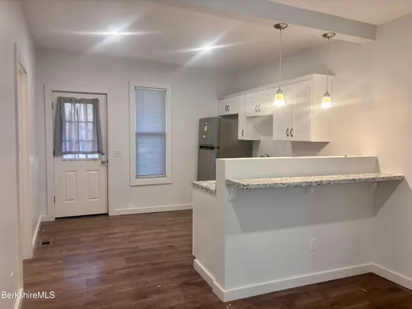 a view of a kitchen with furniture and wooden floor