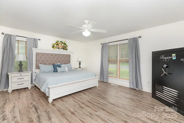 a bedroom with a bed chandelier and a window