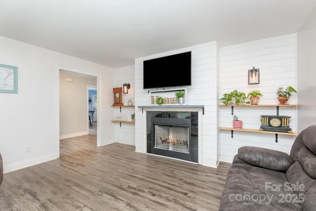 a living room with furniture a flat screen tv and a fireplace