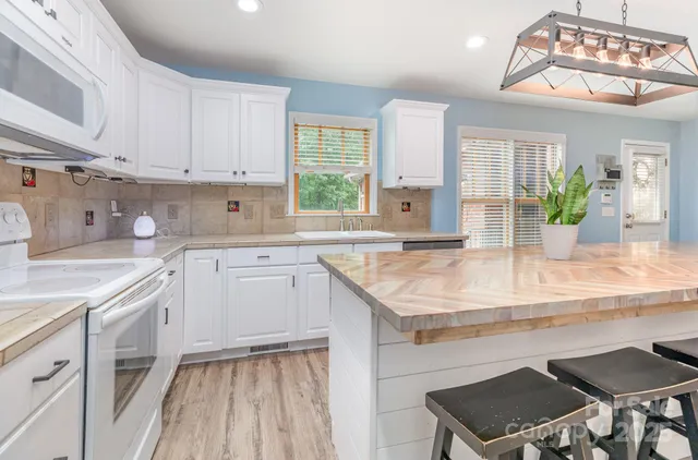 a kitchen with stainless steel appliances kitchen island granite countertop a refrigerator and microwave