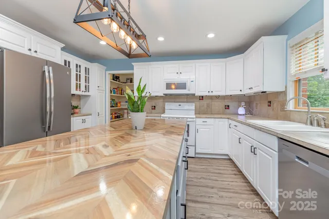 a view of cabinets a oven with wooden floor