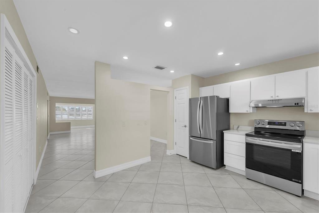 8 Glencoe Place, Unit 105 Dunedin, FL 34698 - Photo 11 of 44 a kitchen with stainless steel appliances granite countertop a refrigerator and a stove top oven